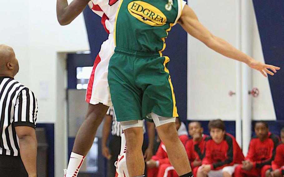 Nile C. Kinnick's Anthony Evans and Robert D. Edgren's Louis Murphy battle for the opening tip during Saturday's DODDS Japan boys high school basketball game at Misawa Air Base, Japan. Kinnick downed Edgren 54-47.