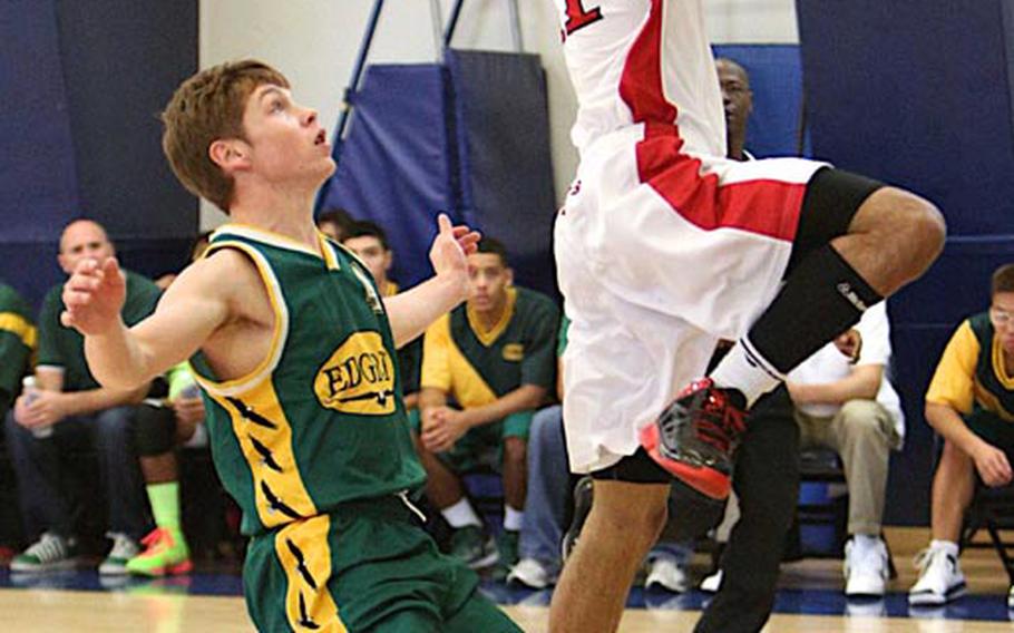 Nile C. Kinnick's Cory Smoak drives past Robert D. Edgren's Chris Finco to the basket during Saturday's DODDS Japan boys high school basketball game at Misawa Air Base, Japan. Kinnick downed Edgren 54-47.