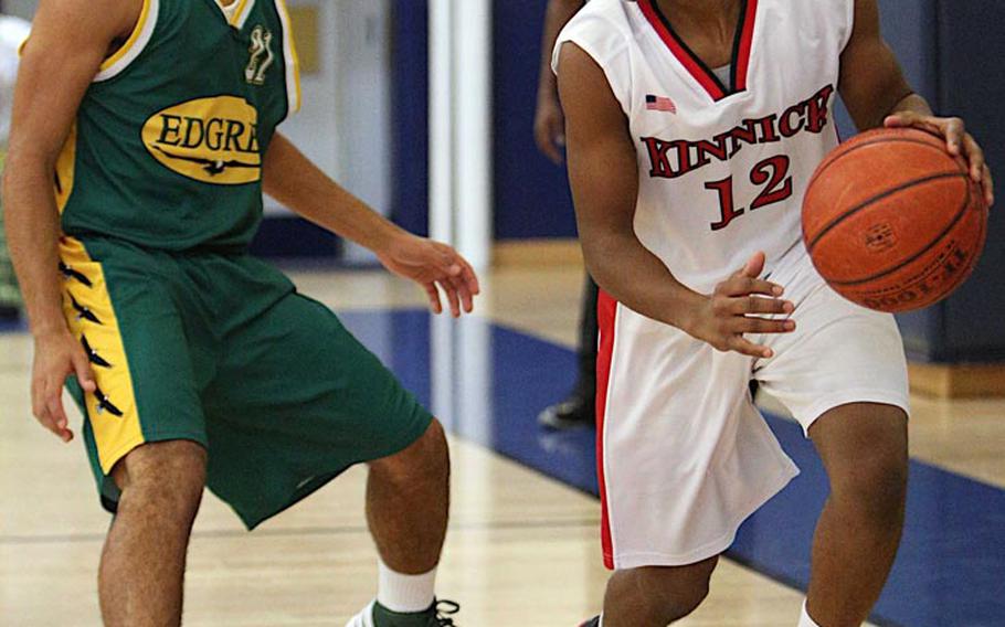 Nile C. Kinnick's Casuan Caudle looks to dribble past Robert D. Edgren's Tristan Jefferson during Saturday's DODDS Japan boys high school basketball game at Misawa Air Base, Japan. Kinnick downed Edgren 54-47.