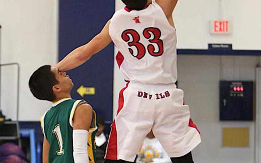 Nile C. Kinnick's Marcel Holden puts a hand to the face of Robert D. Edgren's Tyrone Bacalso as he shoots during Saturday's DODDS Japan boys high school basketball game at Misawa Air Base, Japan. Kinnick downed Edgren 54-47.