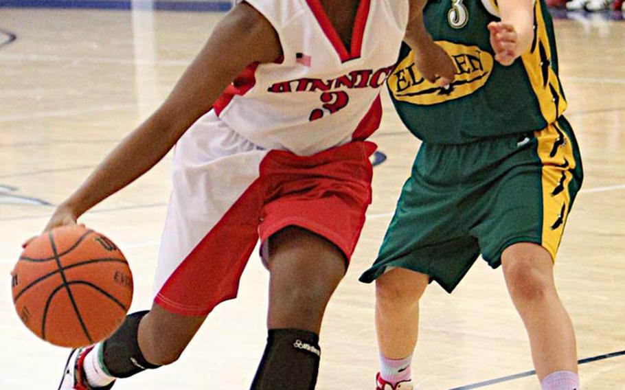 Nile C. Kinnick's De'Asia Brown drives around Robert D. Edgren's Vanessa Black during Saturday's DODDS Japan girls high school basketball game at Misawa Air Base, Japan. Kinnick beat Edgren 40-26.