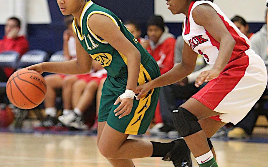 Robert D. Edgren's Ke'iara Davis dribbles against Nile C. Kinnick 's De'Asia Brown during Saturday's DODDS Japan girls high school basketball game at Misawa Air Base, Japan. Kinnick beat Edgren 40-26.