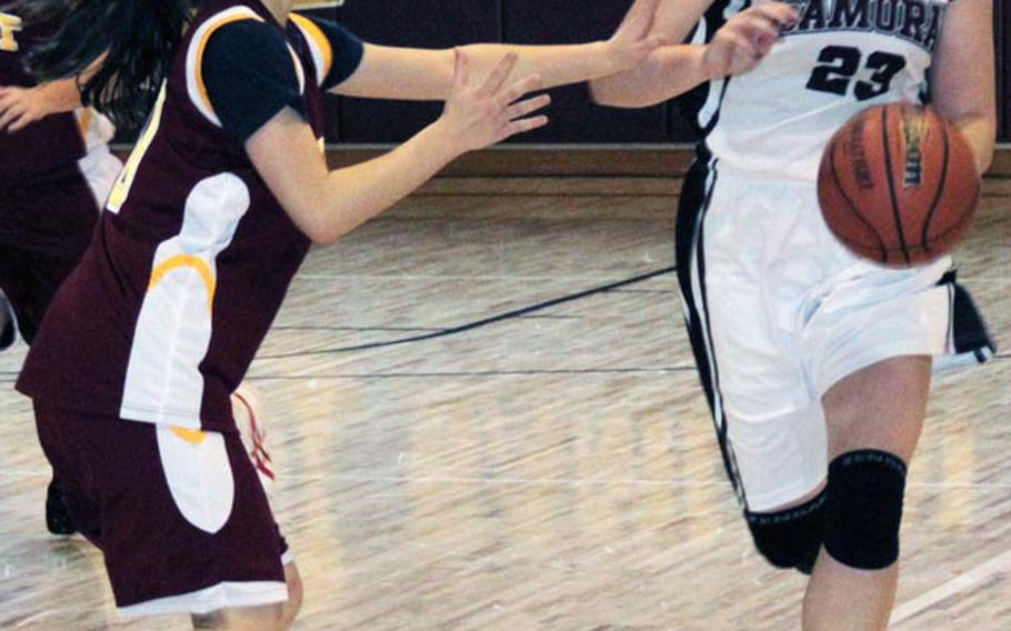 Matthew C. Perry's Courtney Beall dribbles upcourt against Rie Shinkawa of the Marist Brothers International School during Saturday's high school girls basketball game at Marine Corps Air Station Iwakuni, Japan. The Samurai rallied in the fourth quarter to win 46-36.
