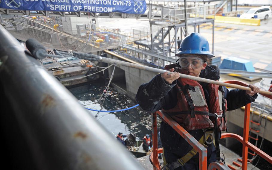 Seaman Casey Perrow paints the side of the aircraft carrier USS George Washington in December. The ship and its strike group could be the only crisis-ready carrier group in the Navy by October if automatic spending cuts set to be triggered in March aren't canceled, according to Navy documents. The Yokosuka, Japan-based carrier is scheduled for a six-month maintenance period, beginning in about a week.