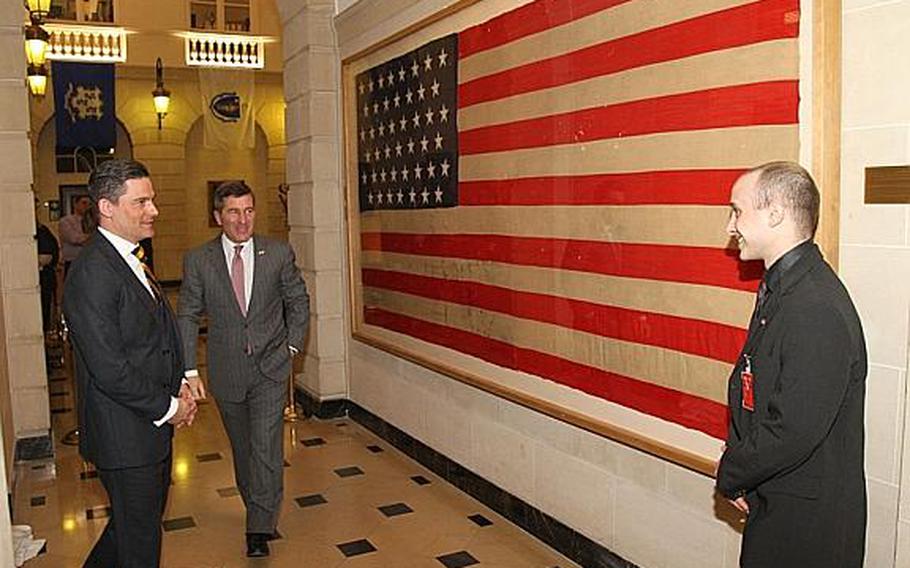 Jean-Baptiste Lapierre stands next to the American flag he donated to the U.S. Embassy in Paris, fulfilling a promise he made to his grandmother to return the flag to American hands. A U.S. soldier gave the flag to Lapierre's grandmother during the liberation of Paris in 1944. On Monday, the flag was unveiled during a ceremony at the embassy. U.S. Ambassador to France Charles H. Rivkin, center, made remarks during the ceremony. At left is Denis Galipeau of the U.S. Defense Attache's Office.