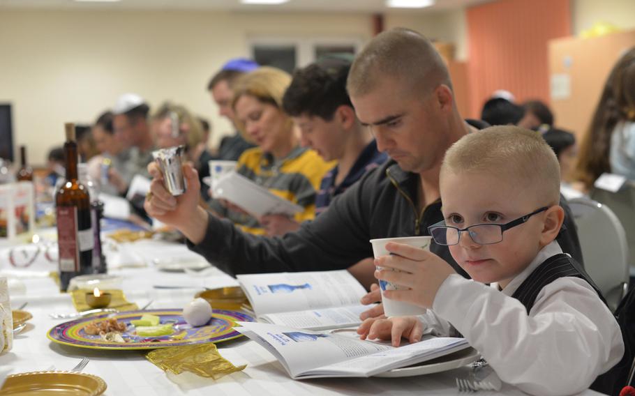 Jonathan French, 5, and his father, Capt. Jonathan French, 32, lift their cups as part of Monday's Passover Seder at the chapel in Grafenwohr, Germany, on Monday. Some 50 people attended the first of four Seders held by U.S. Army Europe's only Jewish chaplain, Capt. Andrew Shulman.