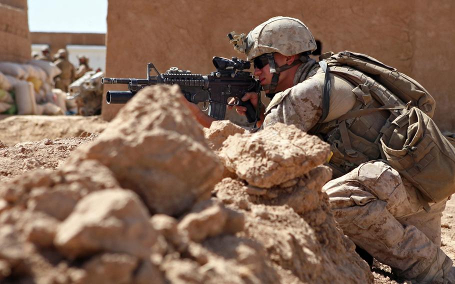 Sgt. Zack Tharp, a reconnaissance Marine with Company A, 2nd Reconnaissance Battalion, Marine Expeditionary Brigade-Afghanistan, provides cover while Marines in the background prepare to destroy confiscated drugs Oct. 6, 2009, at the Salaam Bazaar in Helmand province, Afghanistan. The Marines raided the bazaar alongside U.S. Drug Enforcement Administration agents.