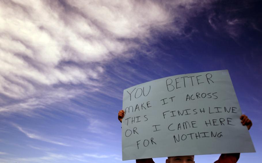 A child of a half-marathon participant holds a sign near the finish line at Joint Base Andrews, Md. The child's mother was participating in her first half-marathon.