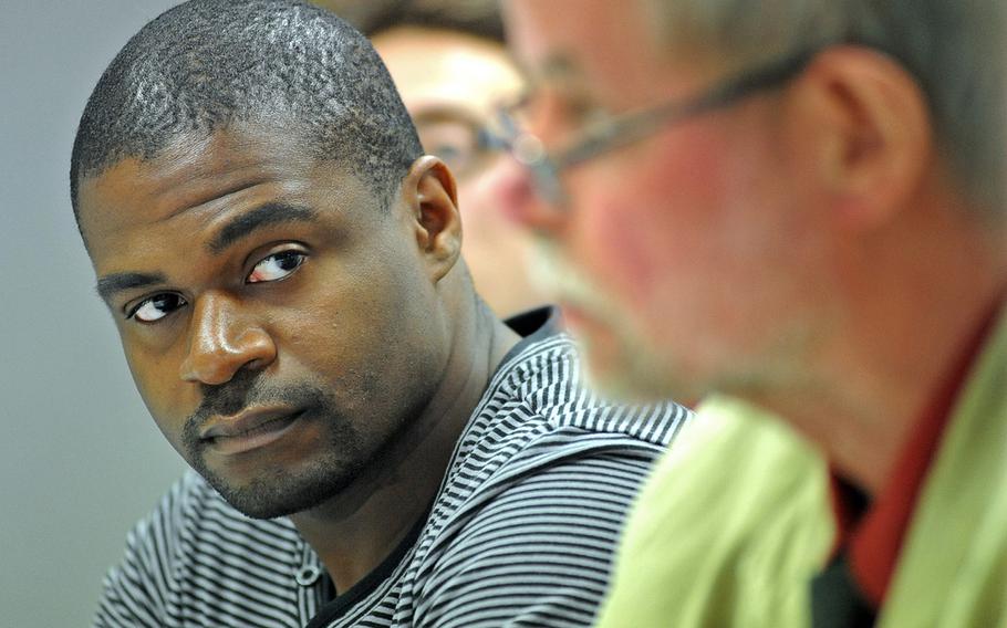 André L. Shepherd, a U.S. Army deserter, listens as his lawyer Reinhard Marx explains why he thinks that German officials were wrong to deny Shepherd's asylum request, at a press conference in Frankfurt, Germany, in 2011.