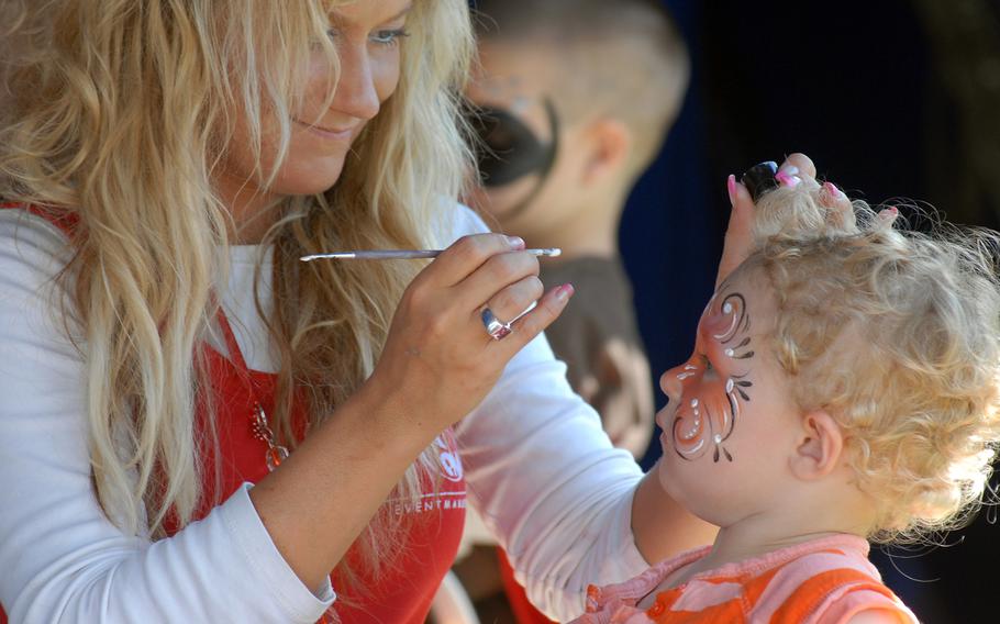 Martina Wittmann paints three-year-old Kaydence Simon's face at Grafenwohr's German-American Volksfest in August 2008.