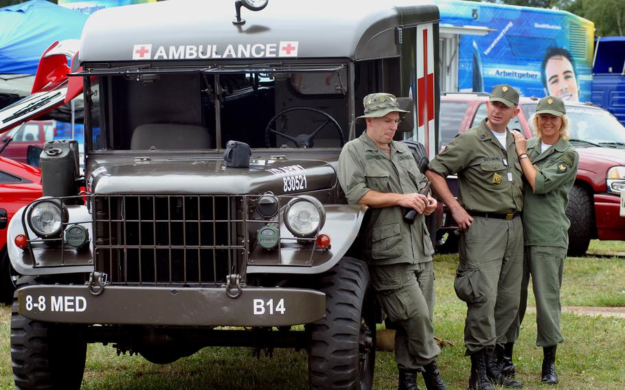From left: German military vehicle collectors Sven Hoerl, Harald Rothmund and Manuela Leug show off an old U.S. field ambulance at Grafenwohr's German-American Volksfest in August 2008.