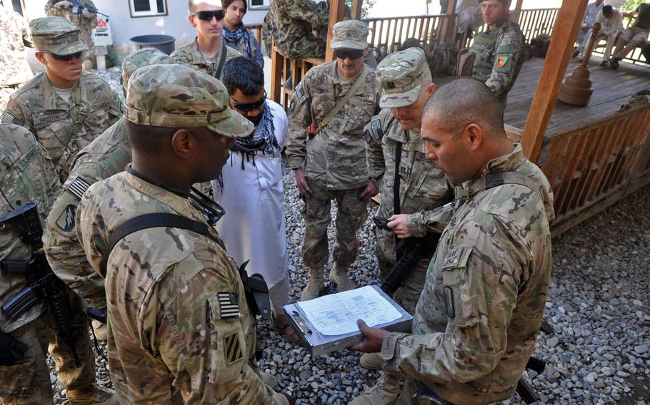 Spc. Marcos Lopez, front right, explains renovation plans to fellow members of the 859th Engineer Company (Vertical) at former Forward Operating Base Hughie. The base was turned over to the Afghan National Army in 2012 and American engineers returned to help train Afghan soldiers to renovate and better maintain the buildings.