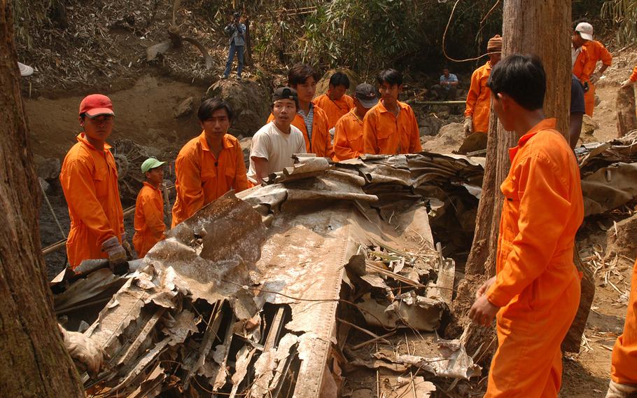 Workmen surround the remains of a downed WWII plane in Burma in this undated photo.The Joint POW/MIA Accounting Command was able to excavate several crash sites in 2003 and 2004 before the Myanmar government suspended operations. JPAC is now back in the country.