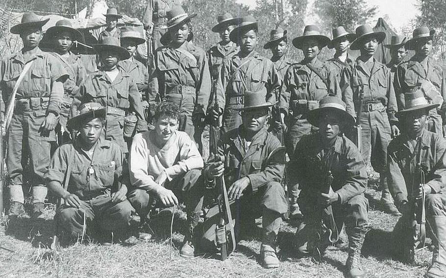 A hatless Sam Spector poses with a group of Kachin Rangers from Company C in 1944. Spector was a radio operator in Burma during World War II and transmitted coded messages via Morse code.