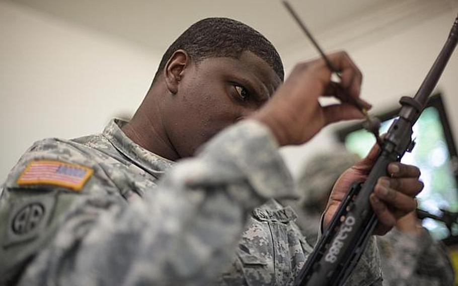 Spc. Nate Simmons, an information technology specialist with Headquarters and Headquarters Company, 1st Battalion, 214th Aviation Regiment, in Wiesbaden, Germany, cleans an M-249 squad automatic weapon at the Monte Kali shooting competition Friday in Wackernheim, Germany.