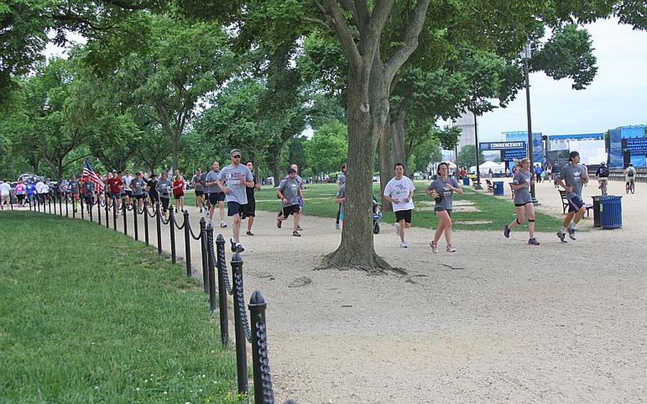 Members of Team RWB and Team Rubicon run along the National Mall in during the "Run as 
                One" event in Washington, D.C., on May 18