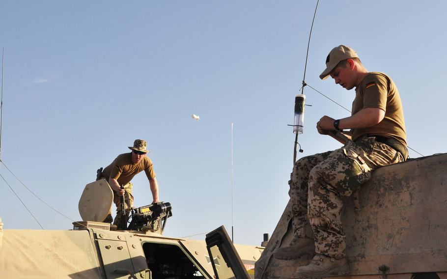 Sgt. Daniel W., left, and Sgt. Maic B. right, prepare their German Dingo truck for a force protection mission in Maza-e-Sharif, Afghanistan.