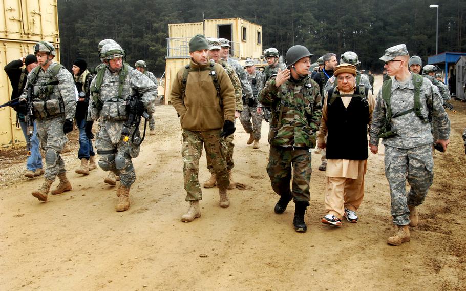 Col. Douglas A. Sims, right, commander of the 2nd Cavalry Regiment, walks with role-players acting as an Afghan government official and an interpreter during the unit's pre-deployment exercise in Hohenfels, Germany, in March.