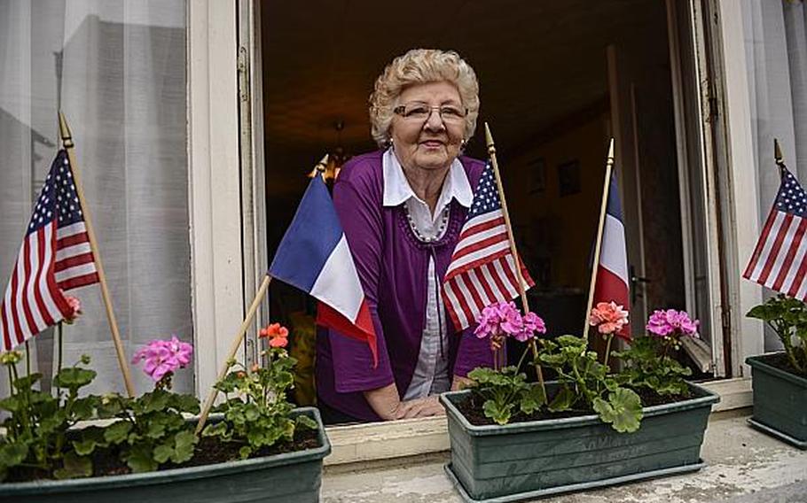 A woman from the village of Romagne-sous-Montfaucon watches the French Band of the Armored Cavalry perform in front of her house after an American Memorial Day ceremony at the nearby Meuse-Argonne Cemetery and Memorial in France. Joshua L. DeMotts/Stars and Stripes