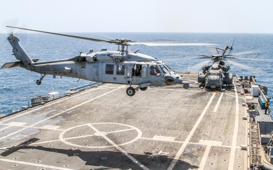 An MH-60 Helicopter takes off from the deck of the USS Ponce while an MH-53 helicopter prepares to take off in support of operations during an international mine countermeasures exercise in the Persian Gulf May 19th.