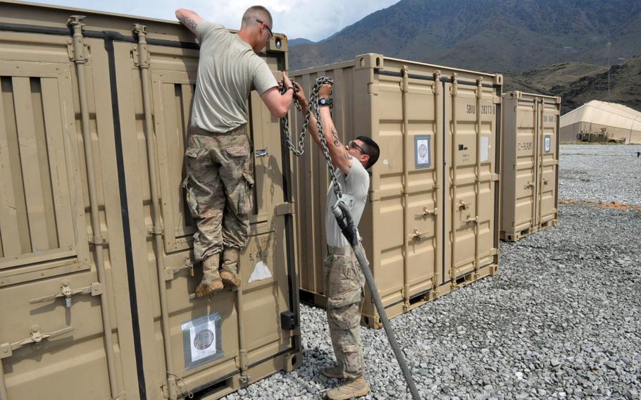 Pfc. Ty Cummings, left, and Sgt. Lucas Strozak prepare a shipping container to be picked up by helicopter at Forward Operating Base Joyce in eastern Afghanistan. The soldiers were packing their equipment after moving to Joyce when Combat Outpost Honaker Miracle was handed over to Afghan forces in June, 2013.
