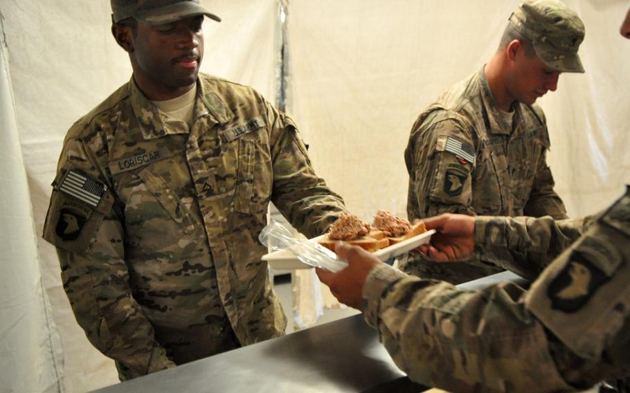 Pfc. Enoch Loiscar, left, and Spc. Mark McDaniel serve sandwiches to other soldiers from the 1st Combat Brigade Team, 101st Airborne Division, based at Forward Operating Base Joyce in eastern Afghanistan. Soldiers have taken over many of the jobs previously done by contractors as troops prepare to hand the base over to the Afghan National Army.
