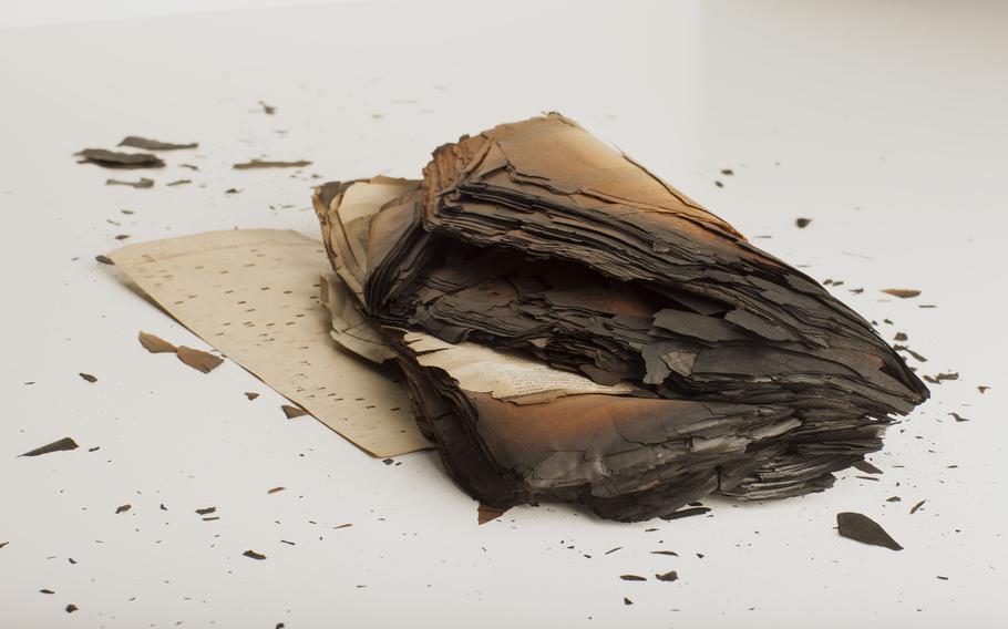 Technicians with the National Personnel Records Center in St. Louis work to recover as much information as they can from burned clumps of documents such as this one. 