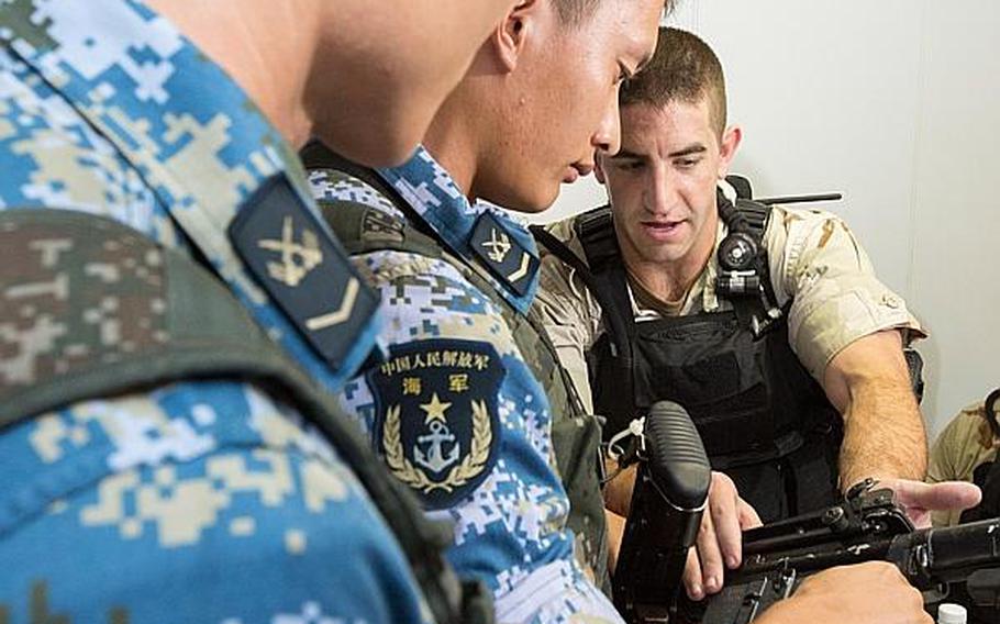 Lt. j.g. Jeffrey Fasoli, gunnery officer aboard the guided-missile destroyer USS Mason, demonstrates how to operate an M4 carbine rifle to Chinese sailors aboard the Chinese destroyer Harbin prior to a combined small-arms exercise in the Gulf of Aden on Saturday, Aug. 24, 2013.
Rob Aylward/ Courtesy of the U.S. Navy