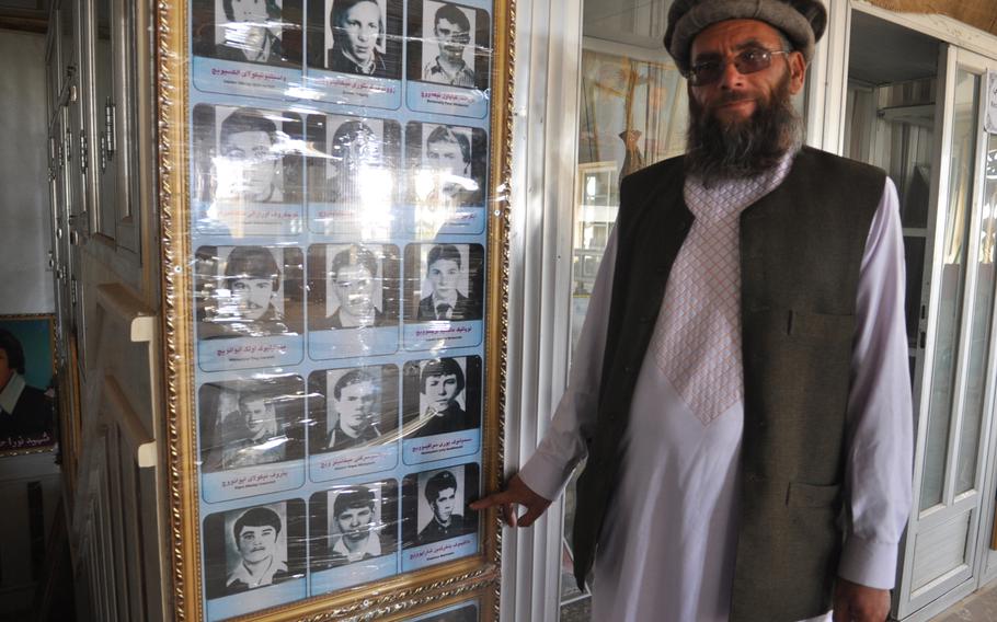 Sheikh Abdullah points at a photo of himself as a young Soviet soldier in Afghanistan, when he went by his birth name, Bakhretdin Khakimov, at Herat, Afghanistan's Jihad Museum.