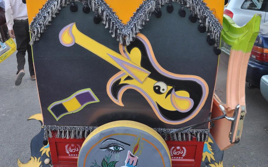 An auto-rickshaw taxi called a seh charkh (three wheels) in Herat, Afghansitan, adorned with a picture of a dutar, a traditional Afghan stringed instrument.