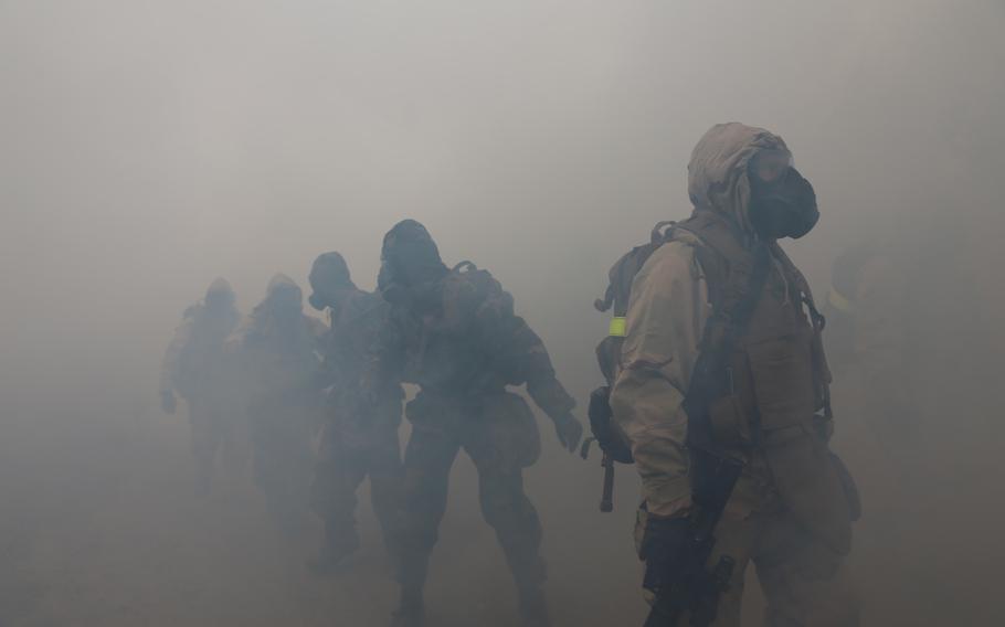 Marines with the 11th Marine Expeditionary Unit move through tear gas during a hike here on Oct 25, 2103.