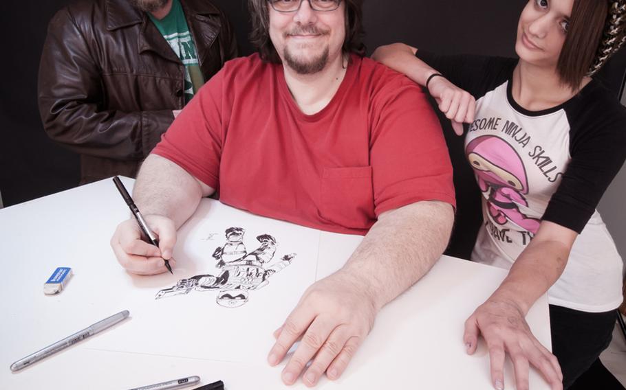 Illustrator Gerry Kissell, center, draws a frame from the soon-to-be-released graphic novel Vindicated Inc. in October at his Springfield, Mo. studios. Kissell is surrounded by his daughter Zoe, right, and co-writer Robert Scott McCall, left, who helped develop the characters and story. 
