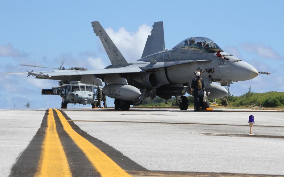 An FA-18D Hornet and a U.S. Navy MH-60S Knighthawk helicopter receive fuel on West Field on Tinian during simulated surge operation as part of Exercise Forager Fury 2012. The Navy and the Marines are exploring the possibility of expanding training opportunities in the region.