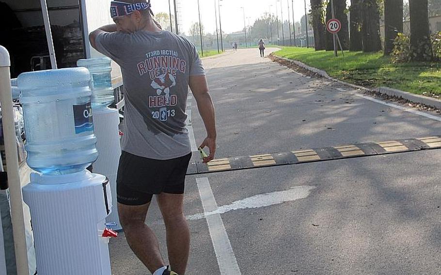 A runner wipes away sweat after completing two laps around the track - nearly five miles - in the Running of the Herd, a relay race commemorating a deadly battle in Vietnam on Nov. 8, 1965 in which 48 soldiers with the 173rd Airborne Brigade died.