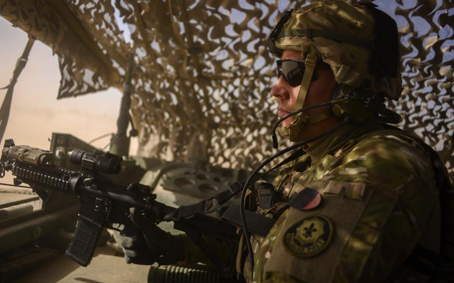 Sgt. Charles Smith with 3rd Squadron, 2nd Cavalry Regiment pulls "air guard" from a hatch in the back of a Stryker during a recent partnered patrol with the Afghan police of a village north of Forward Operating Base Pasab in southern Afghanistan's Kandahar province on Oct. 21, 2013.