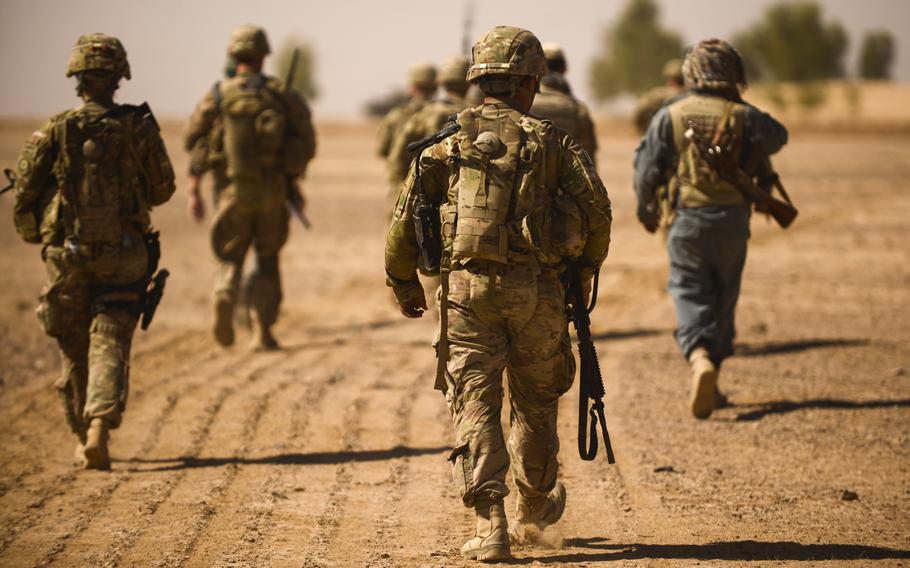 Soldiers with the 2nd Cavalry Regiment and the 163rd Military Intelligence Battalion conduct a partnered patrol with Afghan police in the desert of southern Afghanistan's Kandahar province just north of Forward Operating Base Pasab on Oct. 21, 2013.
