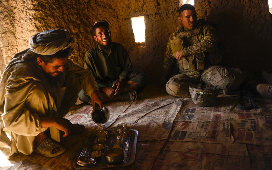 Soldiers with the 2nd Cavalry Regiment, the 163rd Military Intelligence Battalion, along with Afghan police, drink chai with farmers in the desert of southern Afghanistan's Kandahar province just north of Forward Operating Base Pasab on Oct. 21, 2013.