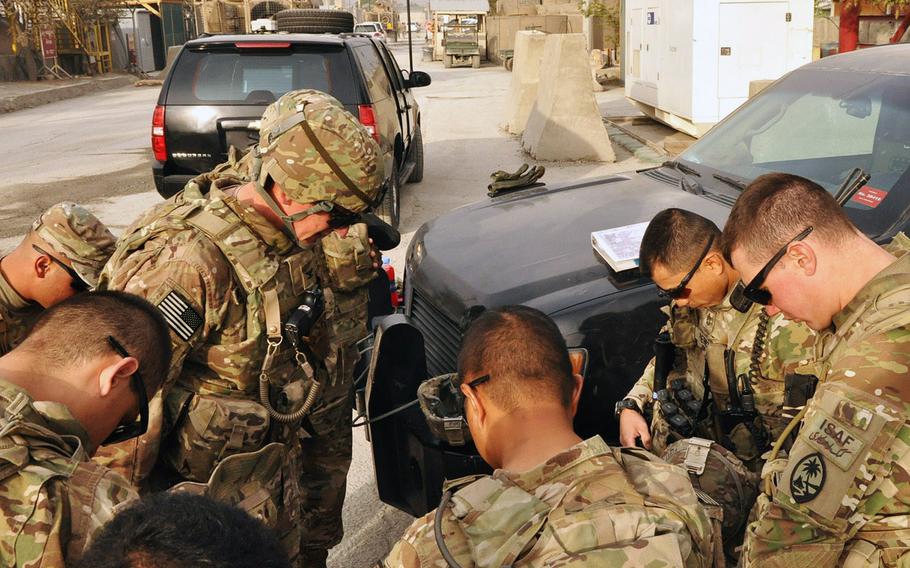 Soldiers from the 1st Battalion, 294th Infantry Regiment, Guam Army National Guard bow their heads and pray before a security escort and guardian angel mission in Kabul. The Task Force includes a group of soldiers who sing at the Catholic mass every Sunday at Camp Phoenix in Kabul.