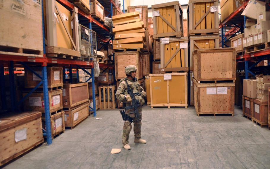 Convoy commander Sgt. 1st Class Christopher D.L. Perez, who is with Task Force Guam's 1st Battalion, 294th Infantry Regiment, stands on guard inside an Afghan National Army supply warehouse in Kabul. Perez was on a guardian angel mission to protect a lieutenant colonel while he spoke with commanders in the Afghan National Army about supplies and logistics for their troops.