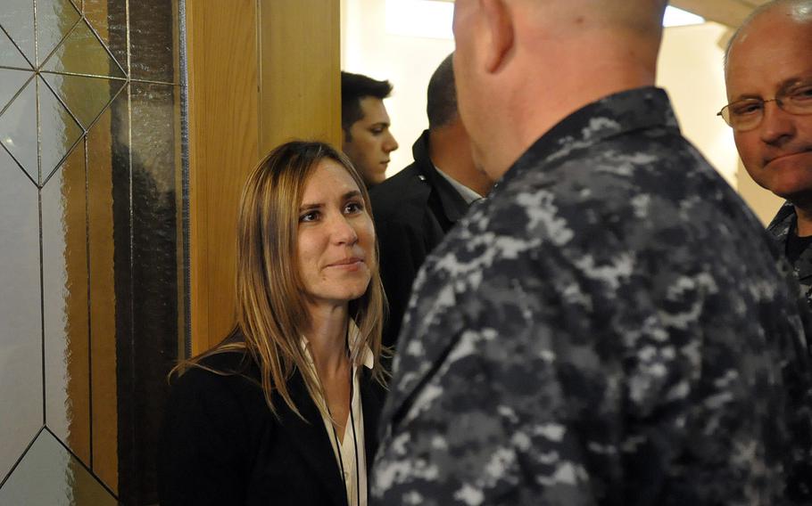 Jennifer Cruz greets Navy personnel in Naples, Italy, following a Nov. 12, 2013, ceremony commemorating the 1988 bombing of the city's former USO club. Cruz's sister, Petty Officer 3rd Class Angela Santos, was one of five people killed in the blast.