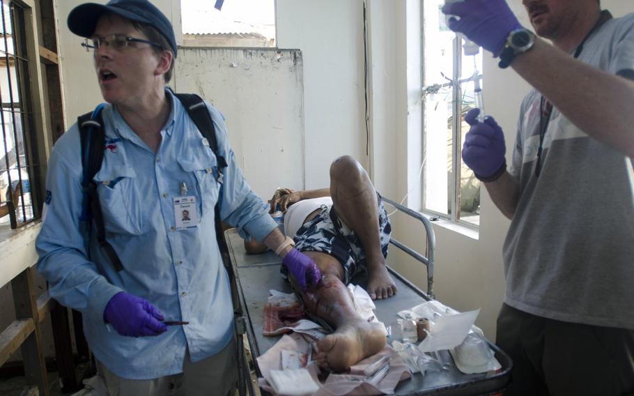 A team of Australian surgeons and American paramedics work to save the leg of a Filipino typhoon victim from amputation at Tacloban Airport November 16, 2013.
