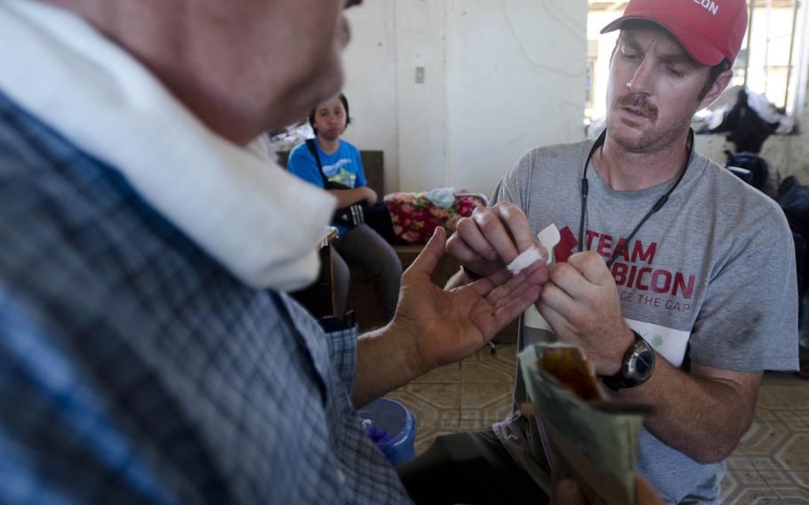 Breaux Burns, a paramedic and former active duty Marine, tests a patient's blood sugar levels at a field hospital in Tacloban, Philippines, Nov. 15, 2013. Eric Guzman/Stars and Stripes