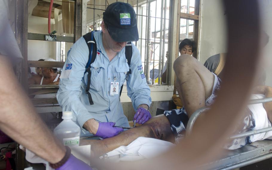 A team of Australian surgeons and American paramedics works to save a man's leg from amputation at Tacloban Airport in the Philippines on Nov. 15, 2013. Eric Guzman/Stars and Stripes