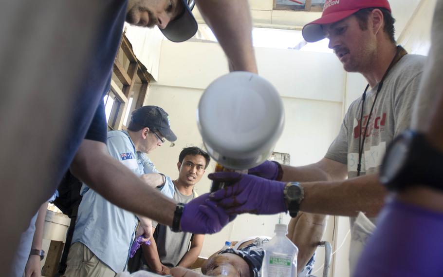 A team of Australian surgeons and American paramedics works to save a man's leg from amputation at Tacloban Airport Nov. 15, 2013. Eric Guzman/Stars and Stripes
