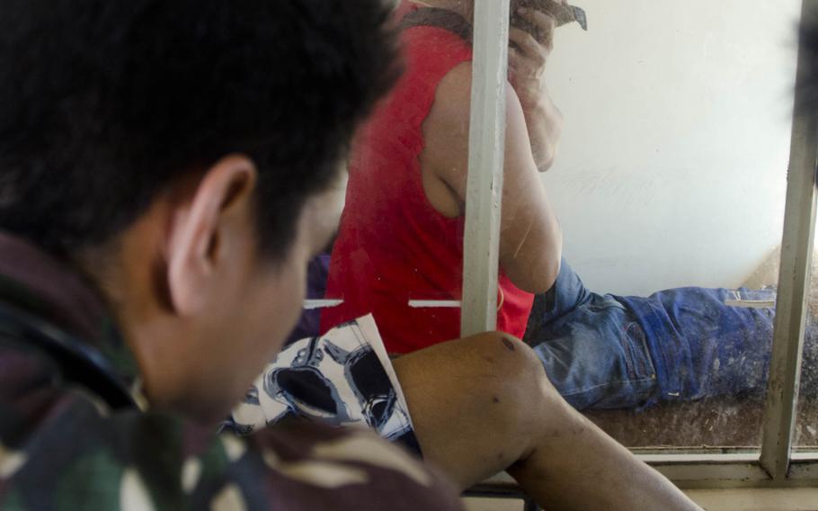 A patient at a field hospital in Tacloban, Philippines, looks on as doctors assess the injuries of another patient on Nov. 15, 2013. Eric Guzman/Stars and Stripes