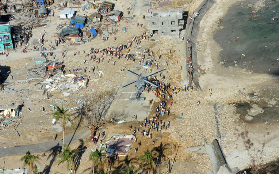 Philippine citizens gather around a MH-60S Seahawk from the "Golden Falcons" of Helicopter Sea Combat Squadron (HSC) 12 as it delivers relief supplies in support of Operation Damayan. The George Washington Strike Group supports the 3d Marine Expeditionary Brigade to assist the Philippine government in response to the aftermath of Super Typhoon Haiyan/Yolanda in the Republic of the Philippines.