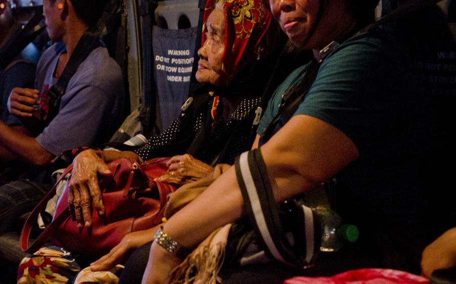Victims of Super Typhoon Haiyan wait for a V-22 Osprey to lift off and deliver them to an evacuation center located at Manila, Philippines, Nov. 18, 2013.