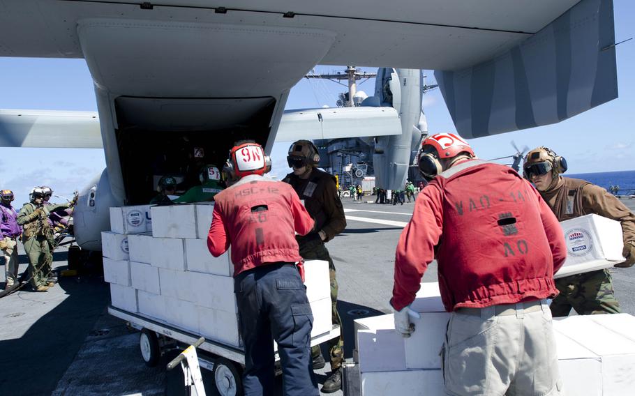 Sailors load relief packages onto a V-22 Osprey as it prepares to leave the USS George Washington to deliver supplies to victims of Super Typhoon Haiyan, Nov. 18, 2013.
