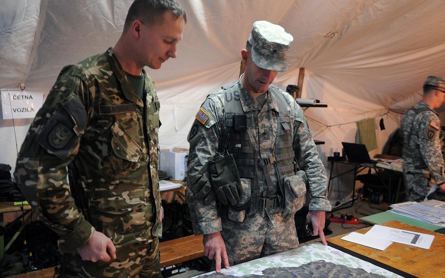 Brig. Gen. Walter Piatt, head of the Joint Multinational Training Command, talks with Slovenian 1st Lt. Savinsek Primoz about tactics on Nov. 13, 2013, during war games at the Army's training center in Hohenfels, Germany. U.S. and European militaries are working together as a multinational combat brigade. The exercise is intended to boost the combat effectiveness of a joint combat unit.