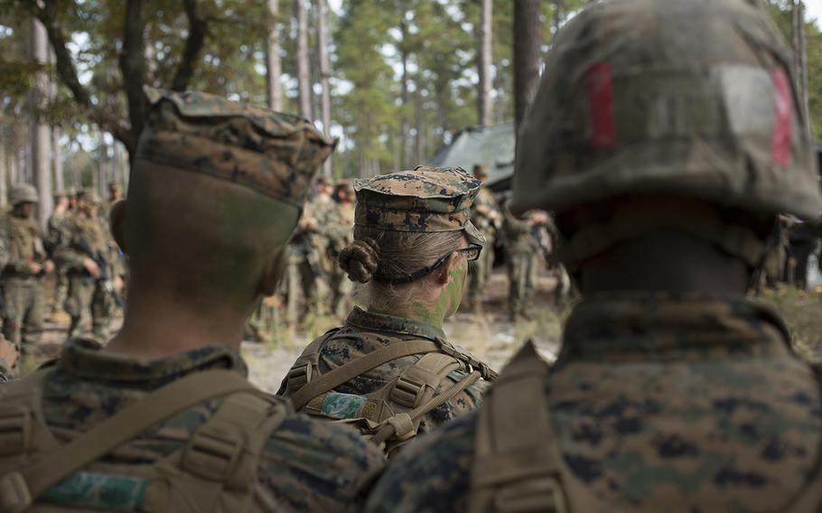 U.S. Marines listen to a combat order brief Nov. 15 before stepping off on a raid, which is part of the Infantry Integrated Field Training Exercise at Camp Geiger, N.C. This is the first company with female students. The Marine Corps is collecting data on the performance of female Marines when executing existing infantry tasks and training events for possible placement in jobs currently limited to males.